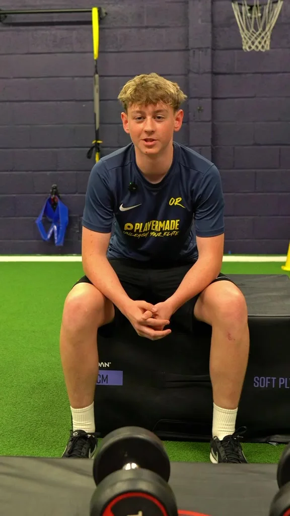 A young athlete seated on the indoor turf during his training interview
