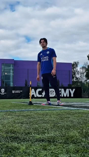 An athlete preparing for training on an outdoor pitch