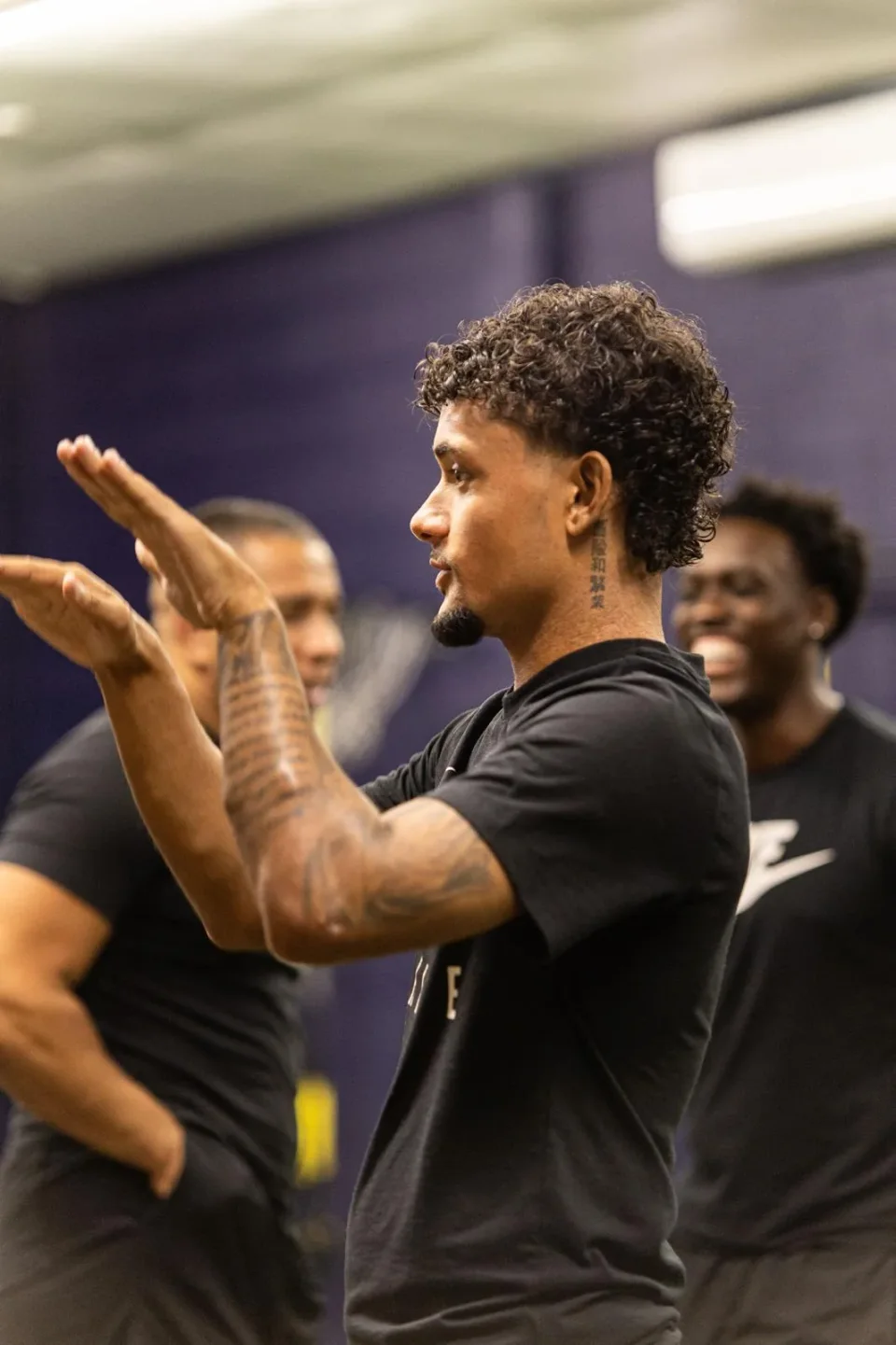 A coach demonstrating a movement with his hands during a practical CPD session