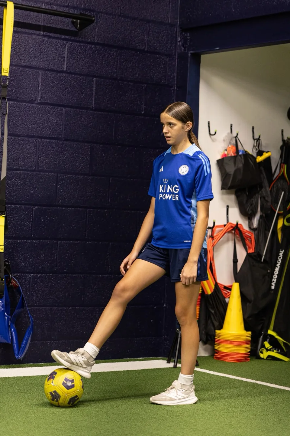 An athlete with a football on Playermade’s indoor turf