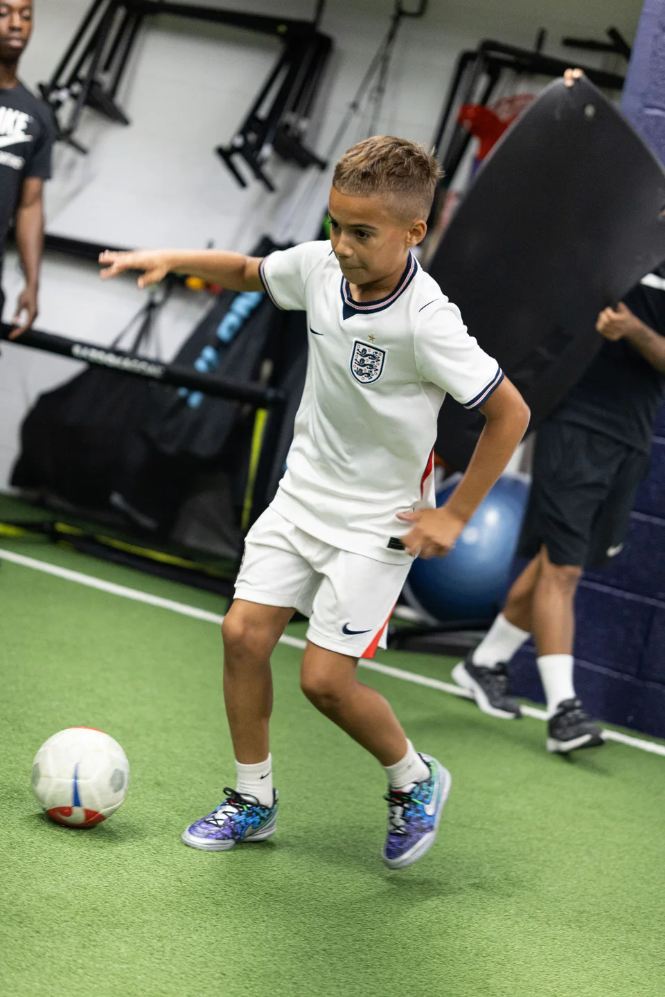 A young footballer practising quick footwork on the indoor turf