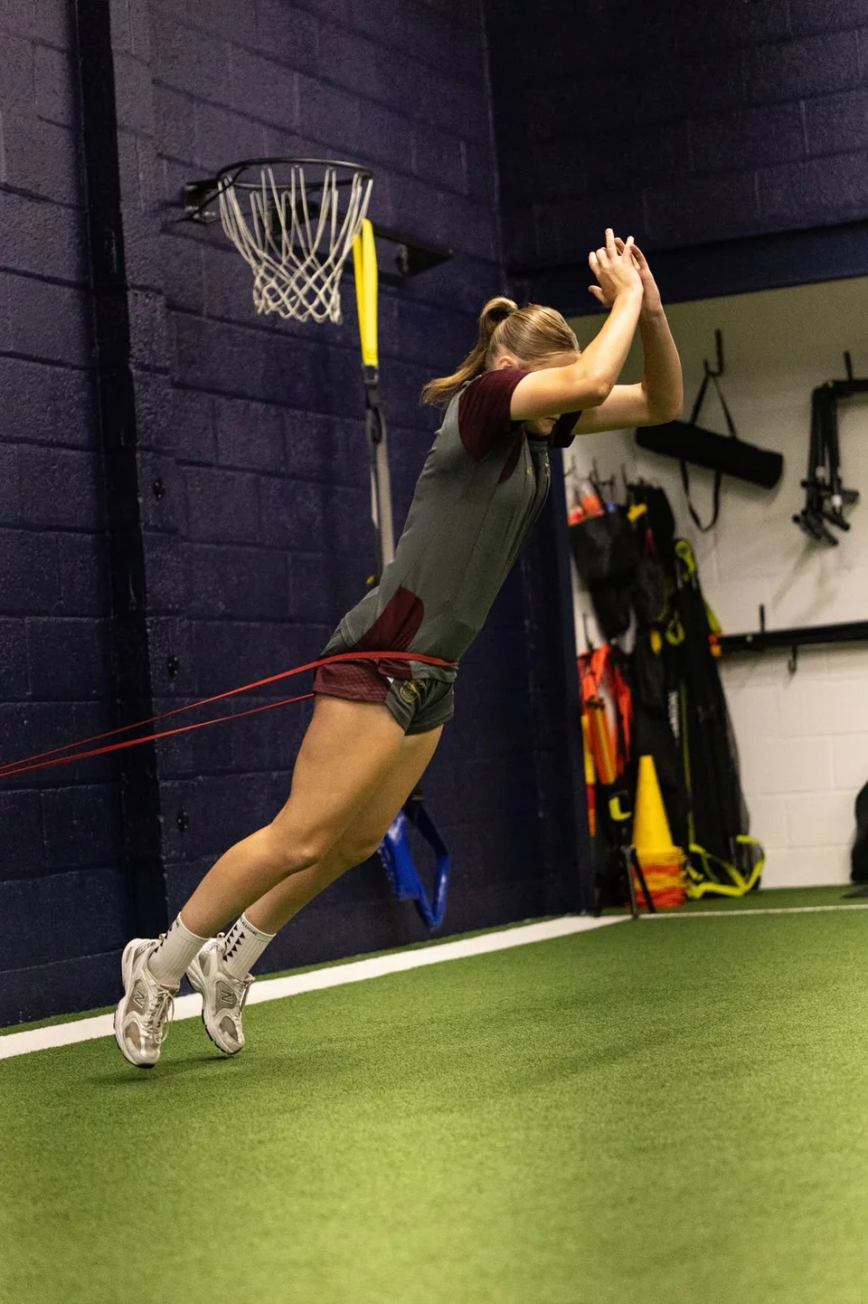 An athlete performing a resisted jump with a training band