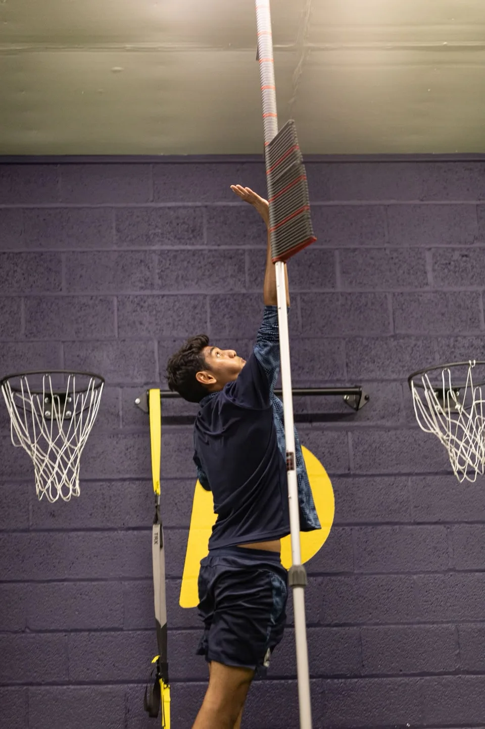 An athlete reaching for a vertical jump test marker